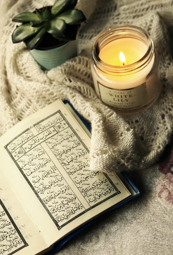 photo of quran beside lighted candle